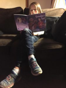Child reading Grandpa's Tent